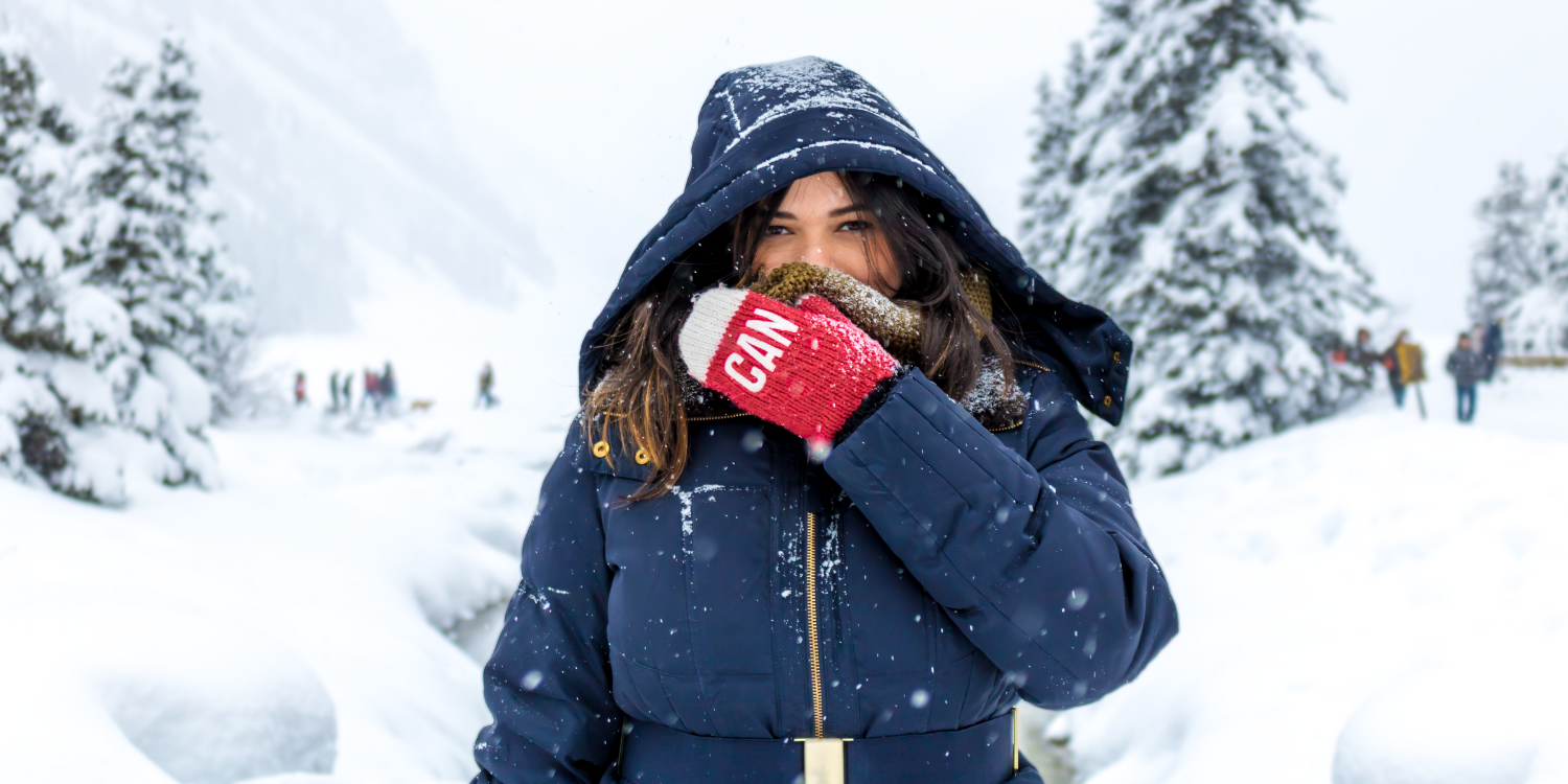 A woman wearing a down jacket standing in the snow