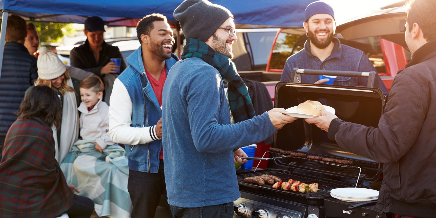 People tailgating outside with a BBQ